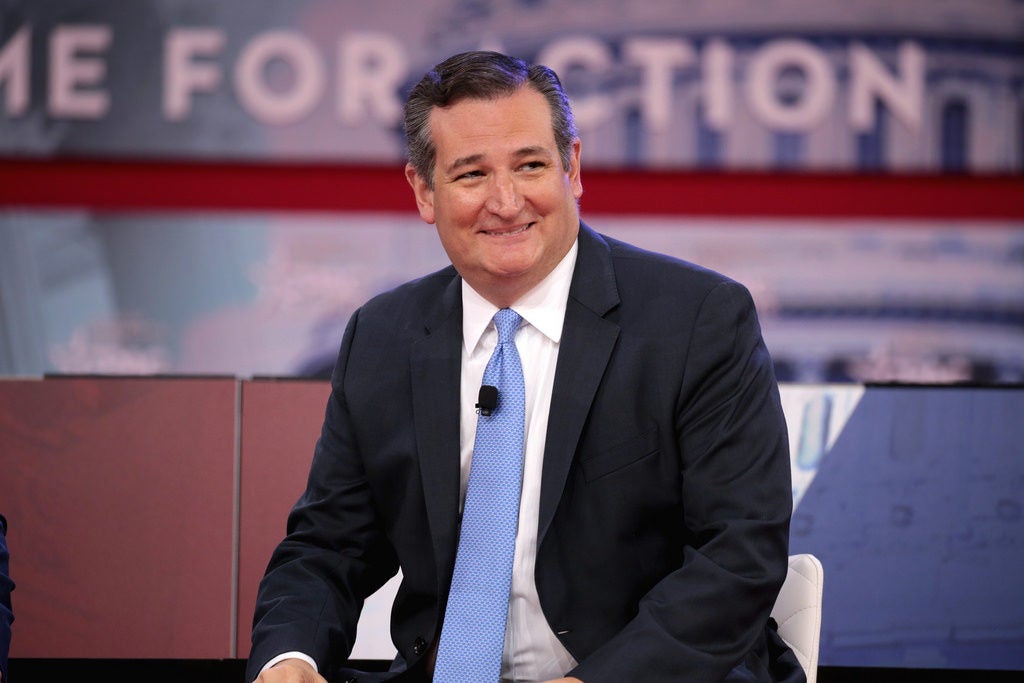 U.S. Senator Ted Crus smiles at an audience looking away from the camera.