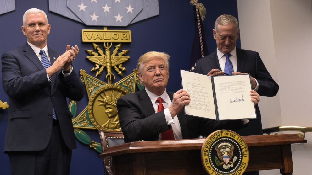 President Donald Trump signs an executive order banning the entry of refugees and immigrants from 7 Muslim nations on January 27, 2017.