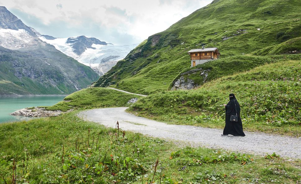 A person wearing a black niqab walks on a path in Zell am See in the province of Salzburg.