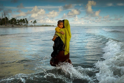 A mother and her child arrives from Myanmar by boat to Bangladesh