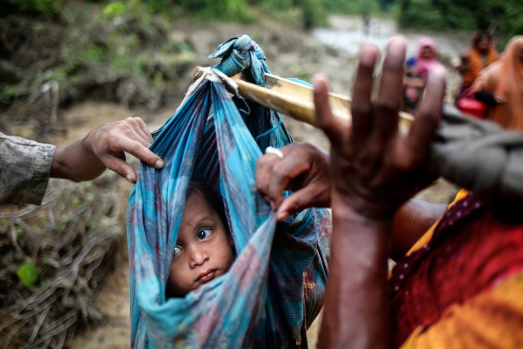 A Rohingya child looks up at the sky as they cross into Bangladesh from Myanmar