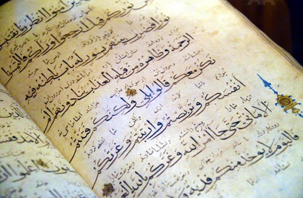 A page of the Islamic holy scripture, the Quran, is shown.