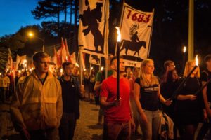 A bnw portrait with a blue overlay with a backdrop of off white described by text in gray and warm red