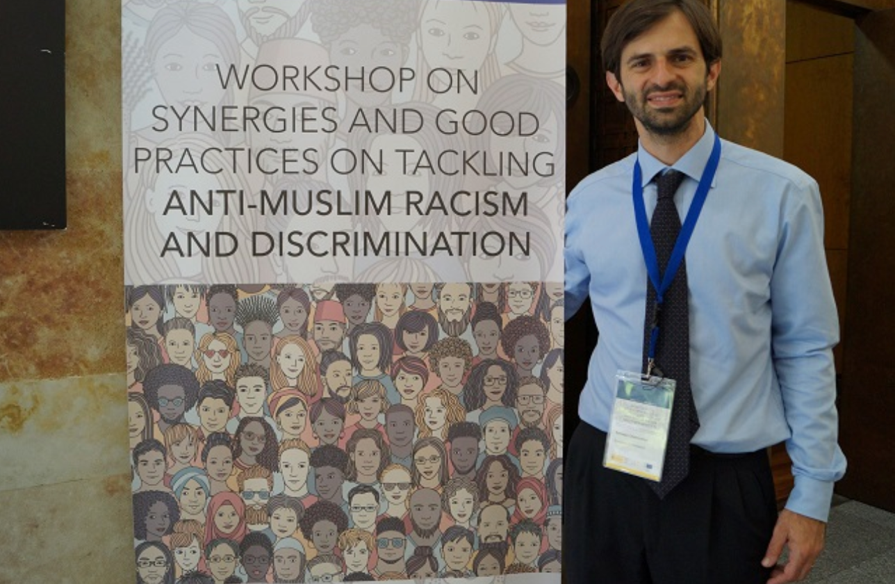 Tommaso Chiamparino stands in front of a sign. He is the coordinator on combating anti-Muslim hatred appointed by the European Commission.