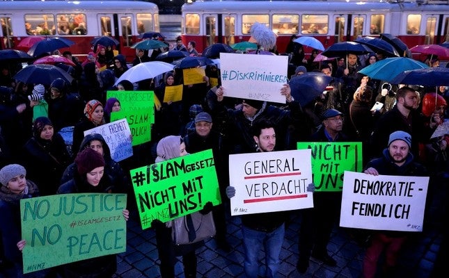Protestors hold sign saying no justice no peace in Austria